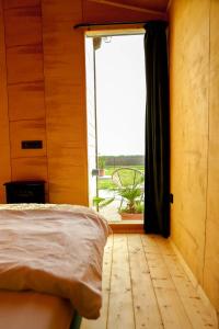 um quarto com uma cama e uma grande janela em ChillHouse by Kis Veréb em Békésszentandrás