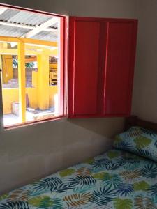 Cama en habitación con ventana en Finca hostal La Alicia 1950, en Santa Marta