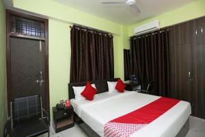 sypialnia z dużym łóżkiem z czerwonymi poduszkami w obiekcie Flagship Near Anisabad Golambar w mieście Patna