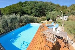 a pool with a wooden deck with a table and chairs at Ferienhaus mit Privatpool für 4 Personen ca 50 qm in Loppeglia, Toskana Provinz Lucca in Loppeglia