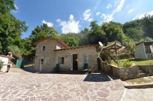 una casa con una entrada de piedra delante de ella en Ferienhaus mit Privatpool für 4 Personen ca 50 qm in Loppeglia, Toskana Provinz Lucca, en Loppeglia