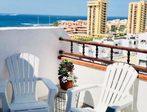 twee witte stoelen en een potplant op een balkon bij Ferienwohnung für 3 Personen ca 45 qm in Playa de Las Américas, Teneriffa Playa de Las Américas und Los Cristianos in Los Cristianos