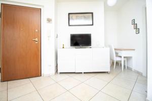 ein Wohnzimmer mit einem TV und einer Tür in der Unterkunft [Balcone Vista Mare] Wi-fi A/c 2 bagni Parcheggi in Porto SantʼElpidio