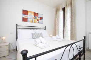 ein weißes Schlafzimmer mit einem Bett mit weißen Kissen in der Unterkunft [Balcone Vista Mare] Wi-fi A/c 2 bagni Parcheggi in Porto SantʼElpidio