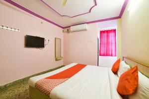 En eller flere senge i et værelse på OYO Radika Residency
