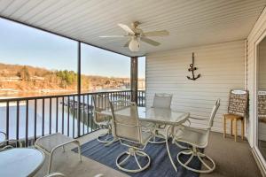 a balcony with a table and chairs and a ceiling fan at Waterfront Condo with Boat Slip! in Lake Ozark