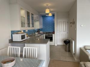 cocina con encimera y microondas en Lovely seafront 2 bedroom Apartment 4, en Aberdyfi