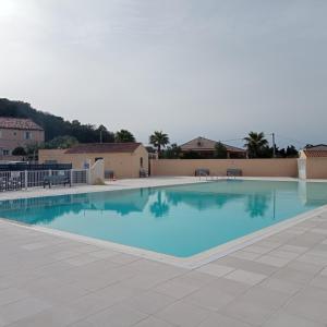 een groot zwembad met blauw water bij Ohana Cottage in Fréjus