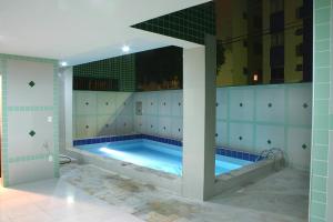a large swimming pool in a bathroom at Rede Andrade GV Center Hotel in Governador Valadares