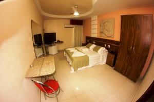 a bedroom with a bed and a television in it at Rede Andrade GV Center Hotel in Governador Valadares