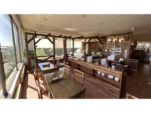 een restaurant met houten tafels, stoelen en ramen bij Hotel Hounomai Otofuke - Vacation STAY 29452v in Otofuke