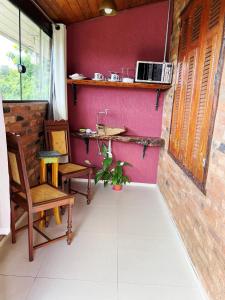 a room with two chairs and a table and a counter at Pousada Mirante da Lua in Lavras Novas