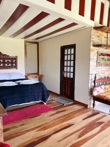 a bedroom with a bed and a wooden floor at Pousada Mirante da Lua in Lavras Novas
