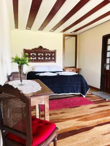 a bedroom with a bed and a table with a table sidx sidx at Pousada Mirante da Lua in Lavras Novas