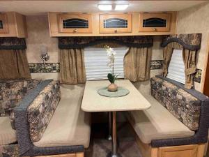 um interior de uma caravana com uma mesa e cadeiras em WARM AND COZY RV 3 em Miami