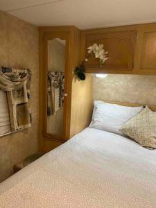 a bedroom with a bed and a cabinet with a flower at WARM AND COZY RV 3 in Miami