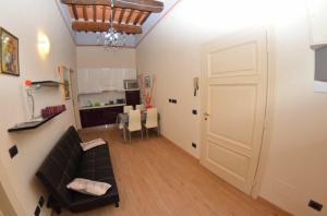 uma sala de estar com um sofá preto e uma porta branca em Ferienwohnung für 4 Personen ca 50 qm in Lucca, Toskana Provinz Lucca em Lucca