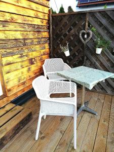 2 sillas y una mesa en una terraza de madera en Ferienhaus in Fertrákos mit Garten, Terrasse und Grill, en Fertőrákos