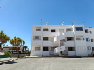 un edificio de apartamentos blanco con balcones blancos y palmeras en Apartamento Praia da Gale en Albufeira