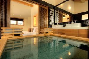 a bathroom with a swimming pool and a bathroom with a sink at Annabelle - Vacation STAY 28455v in Niseko