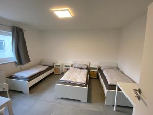 een kamer met 2 bedden en een raam bij OWL Comfort Homes - Monteurwohnung/ Handwerkerunterkunft in Porta Westfalica