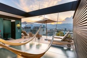 a hammock on the balcony of a house at Celestino Boutique Hotel in Medellín