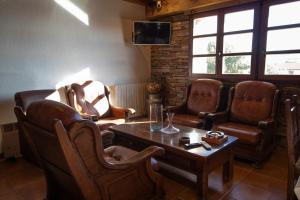 a waiting room with leather chairs and a table at La Guarida de la Lleira in Ferreras de Arriba