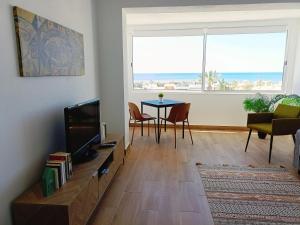 a living room with a television and a table with chairs at Apartamento Praia da Gale in Albufeira