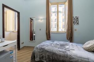 a bedroom with a bed and two windows at ESQUILINO HARMONY GUESTHOUSE - close to COLOSSEUM in Rome