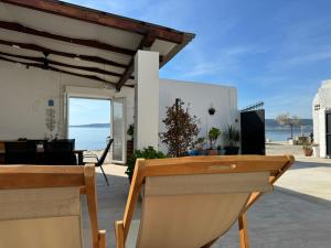 Blick auf ein Haus mit einem Tisch und Stühlen in der Unterkunft Beach house oasis Villa Livak in Kaštela