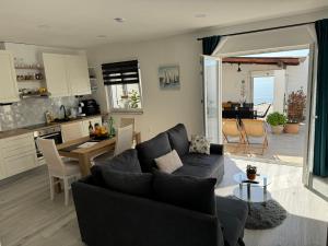 a living room with a couch and a table and a kitchen at Intimate beachfront house Villa Livak in Kaštela