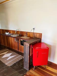 a bathroom with a sink and a red cooler at Pousada Mirante da Lua in Lavras Novas