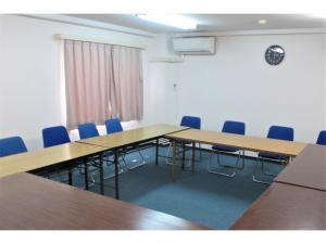 una sala de conferencias con mesas de madera y sillas azules en Kikai Daiichi Hotel - Vacation STAY 30438v, 