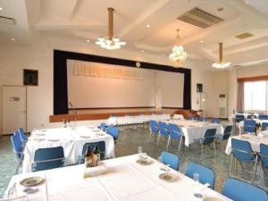 une salle de conférence avec des tables et des chaises et un écran de projection dans l'établissement Kikai Daiichi Hotel - Vacation STAY 30386v, 