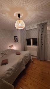 Schlafzimmer mit einem Bett und einem Kronleuchter in der Unterkunft Mysig stuga i Svärtinge in Svärtinge