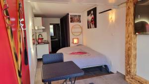 a small bedroom with a bed and a chair at Phantasme Naturiste Studio Terrasse Port Nature in Cap d'Agde