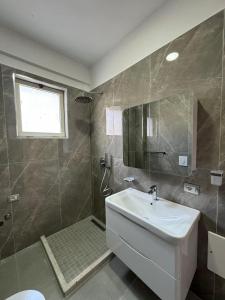 都拉斯的住宿－Vila Melisa，浴室配有白色水槽和淋浴。