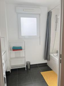 a white bathroom with a window and a shower at Appart Charme Contemporain et Balcon Verdoyant à Bois-Colombes in Bois-Colombes +38 photos