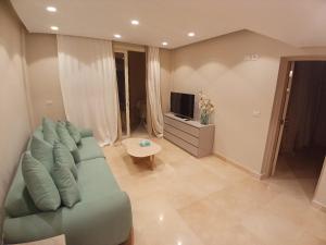 Una sala de estar con un sofá verde y un televisor. en El Gouna, en Hurghada