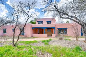 a pink house with trees in front of it at Adobe St David Vacation Rental Near River! 