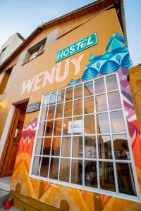 una tienda con un cartel en un lado de un edificio en Hostel Wenuy- en El Chaltén