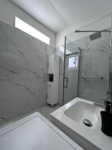 a white bathroom with a sink and a shower at Cazare La Luiza b in Şura Mare +58 photos