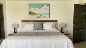 Green Platinum Hotel في تونسوبا: غرفة نوم بسرير كبير فيها مصباحين