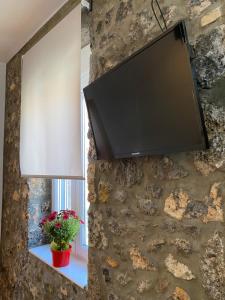 a flat screen tv hanging on a stone wall at OINEAS 