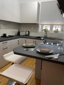 a kitchen with white cabinets and a black counter top at OINEAS 