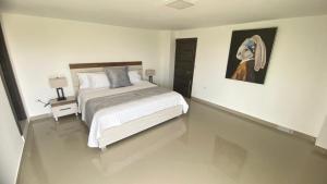 Green Platinum Hotel في تونسوبا: غرفة نوم بسرير ودهان على الحائط