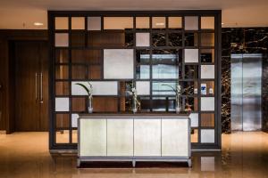 a lobby with a wall of glass and a counter at Oakwood Residence Kapil Hyderabad in Hyderabad