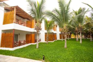 um edifício com palmeiras em frente em Casa Andina Select Zorritos Tumbes em Zorritos