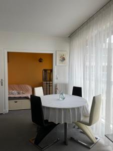 Big apartment with terrace & central location في باريس: غرفة طعام مع طاولة بيضاء وكراسي
