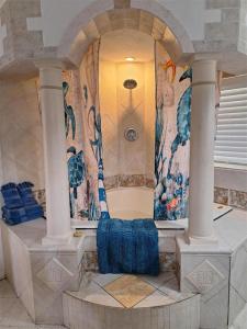 a room with a shower in a building with columns at Blind Pass Resort Motel in St. Pete Beach